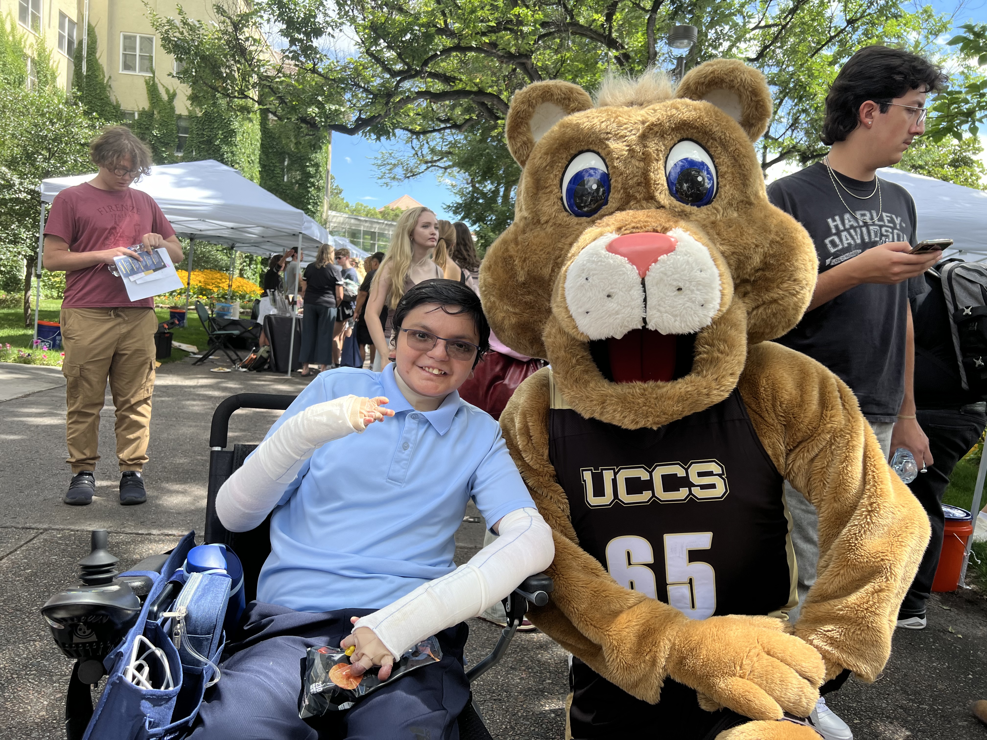 Child with EB in electric wheelchair at a community event